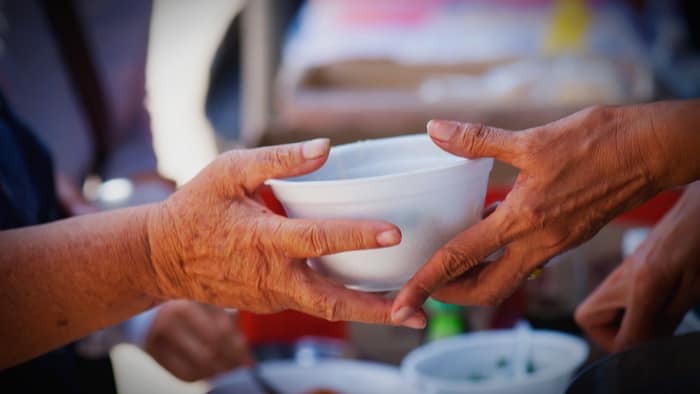 A photo of someone handing a bowl of soup to someone else - a graphic for an event at Open Door Church, serving food to those facing food insecurity in Maple Ridge, BC
